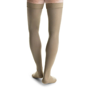 man wearing jobst formen thigh high compression sock closed toe in tan khaki, back view