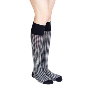 leg wearing medi rejuva high knee compression sock in houndstooth black and white colour, side view standing