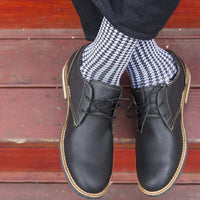 model wearing medi rejuva compression sock in houndstooth black and white colour, cross legged
