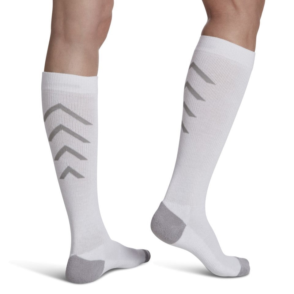 close-up of leg wearing white sigvaris athletic recovery compression sock, back view