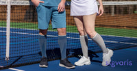 man and woman wearing sigvaris motion flow tech compression sock in blue and grey standing in a tennis court