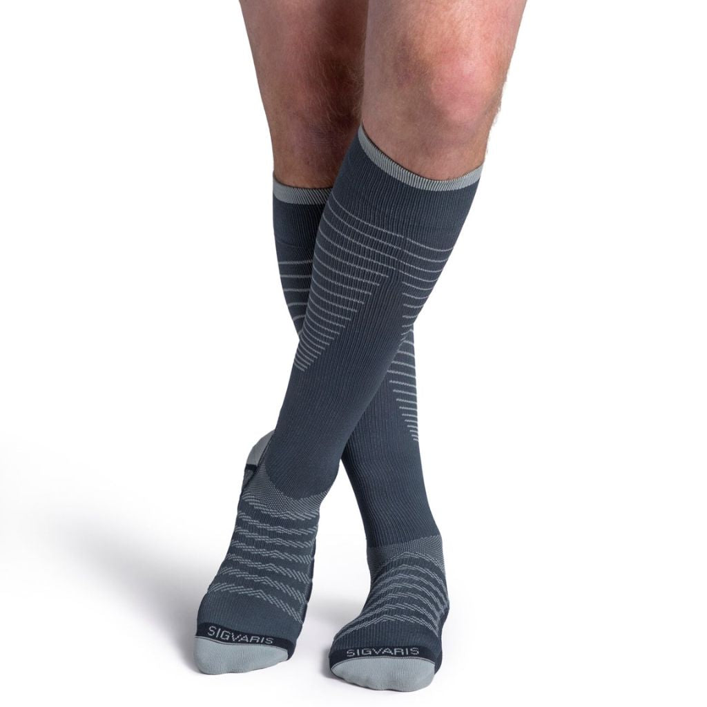 model wearing sigvaris flow tech compression sock in slate, front view.