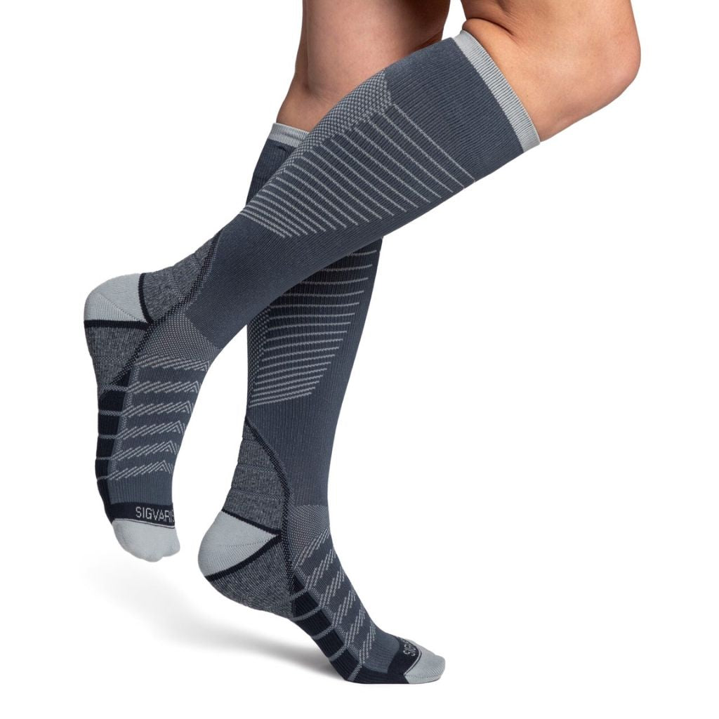 model wearing sigvaris flow tech compression sock in slate, side view.