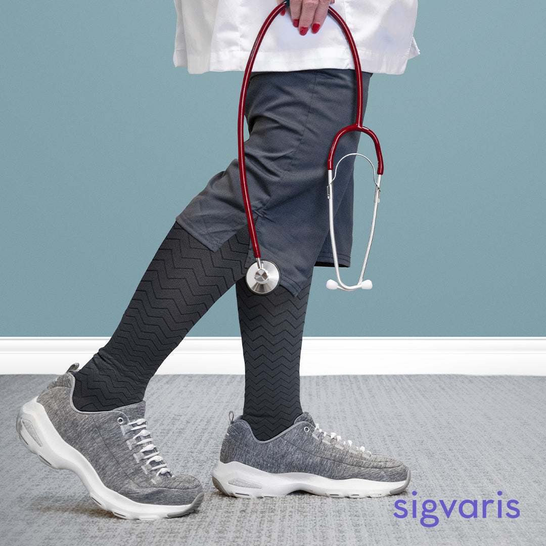 nurse holding a stethoscope wearing the sigvaris microfibre pattern compression sock in graphite chevron