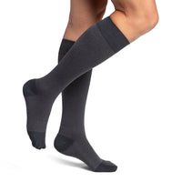 woman model wearing sigvaris microfibre pattern compression sock in graphite confetti, side view.