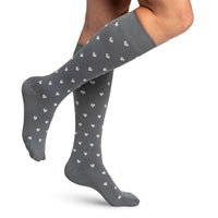 woman model wearing sigvaris microfibre pattern compression sock in grey hearts, side view.