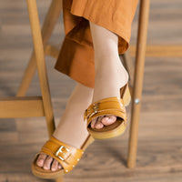 woman wearing light beige sigvaris opaque open toe knee high compression sock with sandals and wide-leg pants
