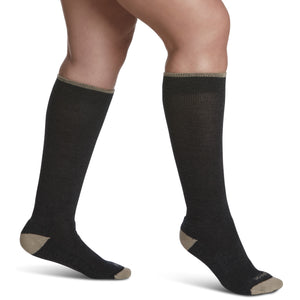 close-up of a leg wearing sigvaris merino wool outdoor compression sock in charcoal colour, side view.